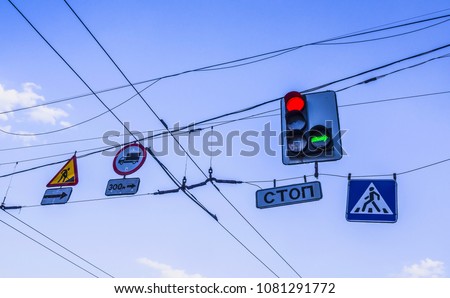 Road signs against the sky. Traffic light. Trolleybus wires