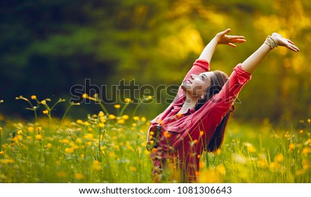 Happy young girl smiling with arms raised outdoor. Freedom and praying concept.  Royalty-Free Stock Photo #1081306643