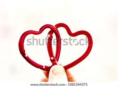 two red carabine in the form of heart against white light. 