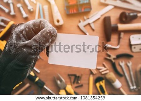 Handyman blank business card as copy space over workshop table with maintenance and fix-up project tools