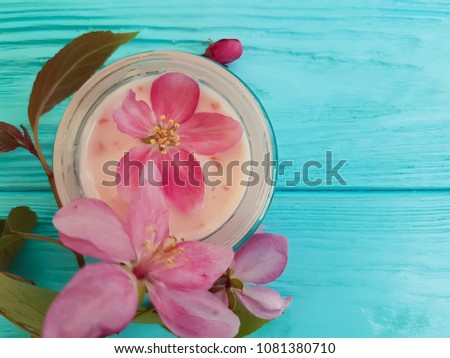 cream cosmetic pink flowers on blue wooden, magnolia towel