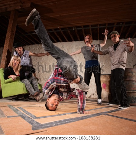 Latino man spinning on his head in break dancing battle Royalty-Free Stock Photo #108138281