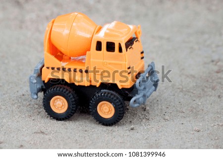 Plastic toy orange color for construction.by Mix cement car on cement floor.
