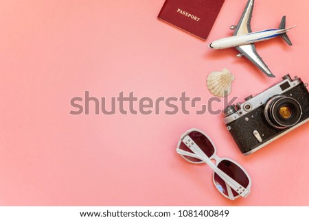 Flat Lay with plane, vintage camera, passport, sunglasses and shell on pink colourful pastel trendy modern fashion background. Vacation travel summer weekend sea adventure trip concept