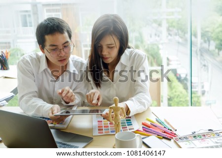 Interior designers teamwork with pantone swatch and paperwork on office desk