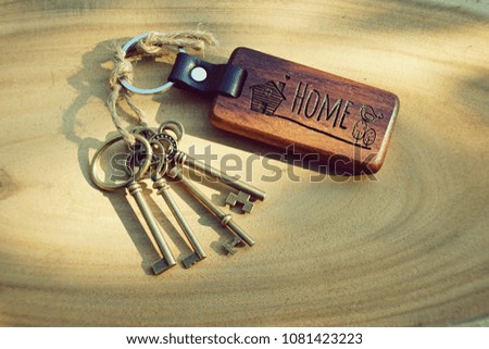 Antique house key with wood home keyring on wooden background