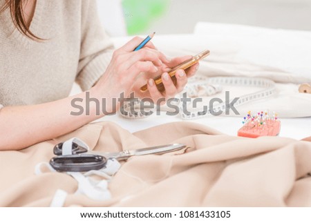 woman seamstress using phone. Side view
