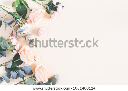 Flowers composition. Frame made of rose flowers and eucalyptus branches on pastel yellow background. Flat lay, top view, copy space