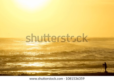 Photographer silhouette in front of an ocean sunset