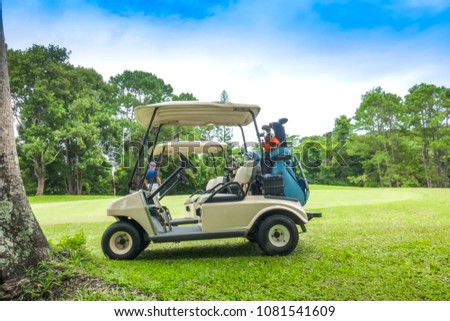 Soft golf cart on fairway of golf course on sky blue or azure sky and forest. Golfer on green for putting ball to hole to the winner
