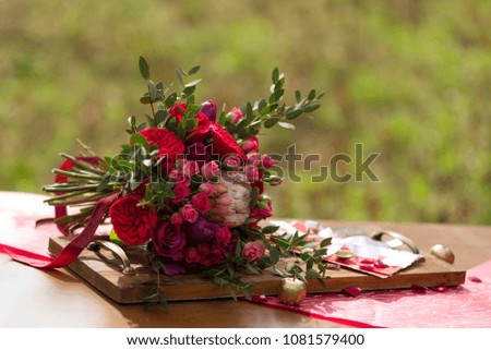 Red wedding bouquet with wedding decor on a table