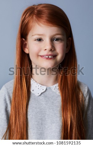 Smiling redheaded girl looking at camera