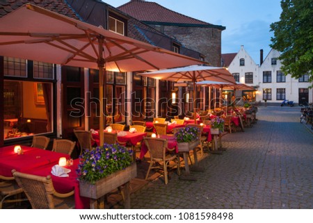 Cafes and restaurants with cozy terraces at nighttime in Bruges, Belgium Royalty-Free Stock Photo #1081598498