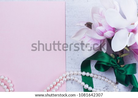 Magnolia flowers and jewellery flat lay composition with copy space on pink paper