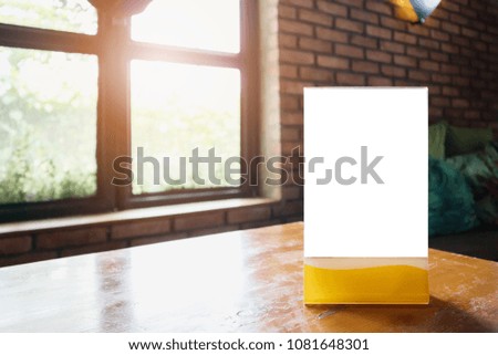 Mockup empty white label menu frame on table with cafe restaurant window interior background