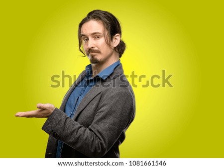 Handsome young man holding something in his empty hand