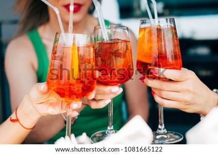 Woman hands toasting with aperol spritz cocktails Royalty-Free Stock Photo #1081665122