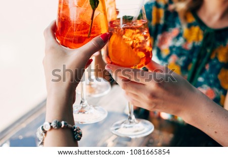 Toast with aperol spritz coctails in hends Royalty-Free Stock Photo #1081665854