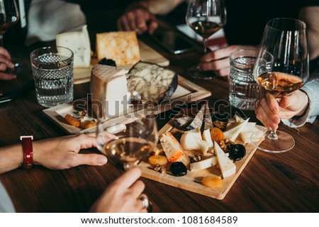Wine and cheese served for a friendly party in a bar or a restaurant. Royalty-Free Stock Photo #1081684589