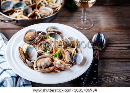 Traditional italian seafood pasta with clams Spaghetti alle Vongole on wooden background Royalty-Free Stock Photo #1081706984
