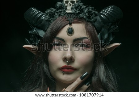 Horned asian girl with elvish ears over dark background