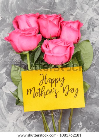 Pink roses and yellow card with an inscription, Happy Mother's Day, on a gray concrete background Royalty-Free Stock Photo #1081762181
