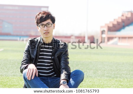 A handsome young asian male student on the playground