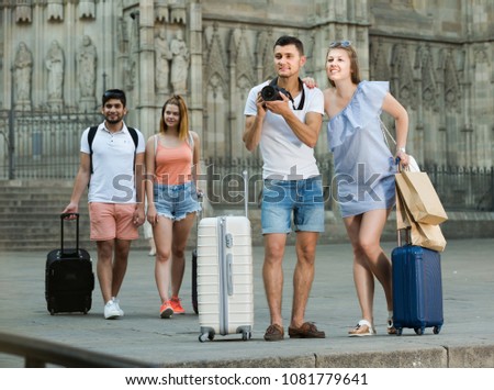 Young couple of tourists taking picture with camera in town while traveling
