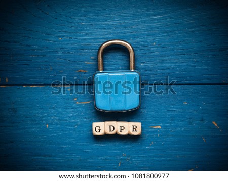 Old used padlock on a blue rustic wooden background, GDPR concept image