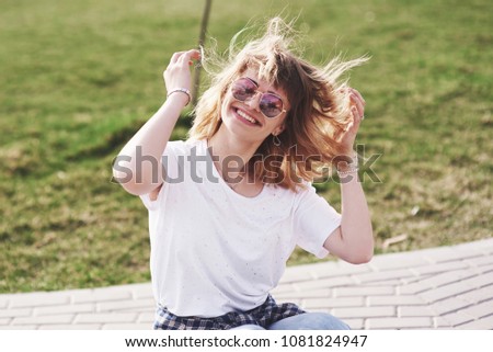 Outdoor summer lifestyle image of young pretty hipster woman having fun. Soft sunny colors.