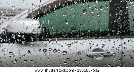 
Rain falls on a car.