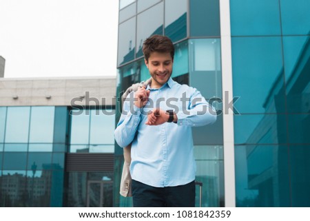 It is happy spare time! Handsome delightful businessman with charming smile having leisure time, while waiting for his flight in the airport. Royalty-Free Stock Photo #1081842359