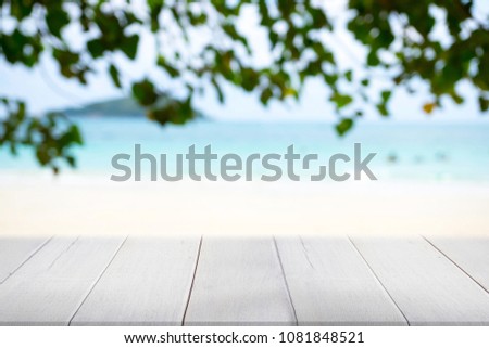 Beautiful view of  blue sea and white beach with leaves foreground and mountain background.Blur image.