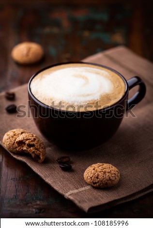 Cup of cafe au lait and tasty cookies. Cup of latte coffee with biscotti. Symbolic image. Rustic wooden background. Close up.  Royalty-Free Stock Photo #108185996