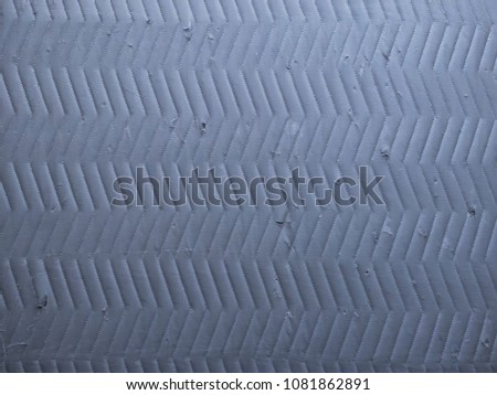 herringbone quilted angle lines on cool gray distressed moving blanket or tarp