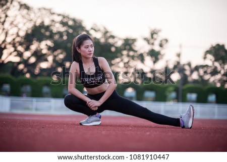 Young sport woman stretching and preparing to run. worm up