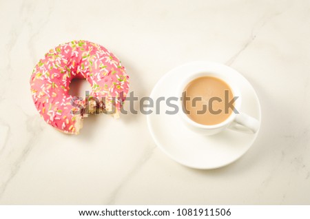Coffee break with bitten donut/Coffee break with bitten donut on a white marble background. Top view