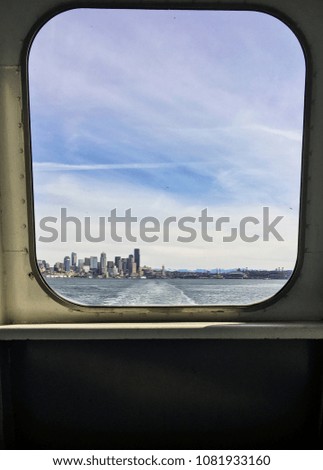 Seattle skyline through Bainbridge ferry window on Puget Sound, WA US
