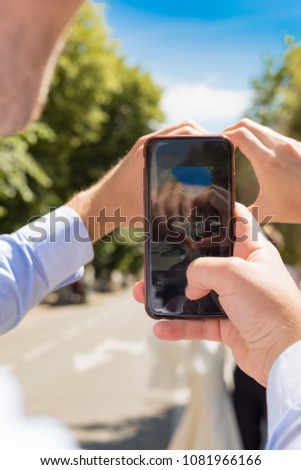 The man holds the phone, the heart takes the bride and groom