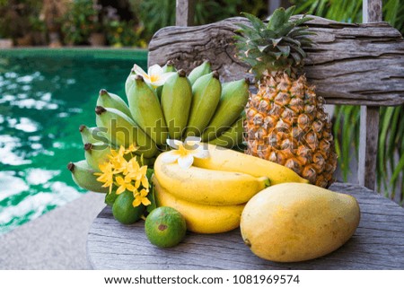 
Bananas, pineapple, lemon, lime, mango and other fruits close-up. Still-life from tropical fruits. Exotic fruits near the pool in the tropics