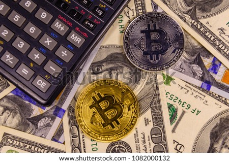 Bitcoins and scientific calculator on one hundred dollar bills. Top view