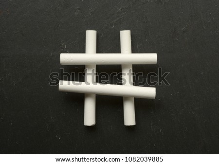 the hashtag symbol made with chalks - black background - closeup