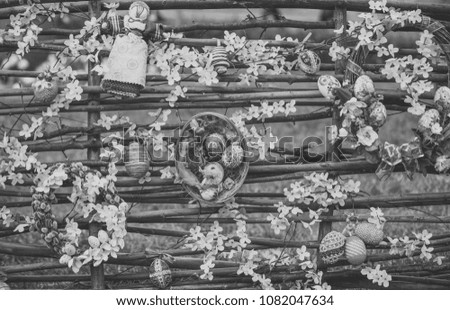 Easter art, decoration, floristry, design. Easter eggs and spring blossom on wicker fence. Happy easter concept. Spring holidays celebration.