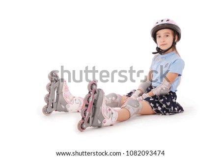 Happy little girl with roller skates and protective gear resting - isolated on white background