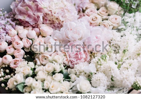 Beautiful flower bed of fresh peonies, roses, hyacinths, hydrangeas, ranunculus in tender pink colors at the florist shop, top view Royalty-Free Stock Photo #1082127320
