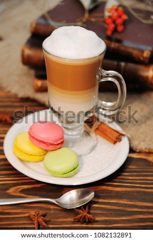 latte and macaroons close-up on a wooden background on a background of old books and burlap