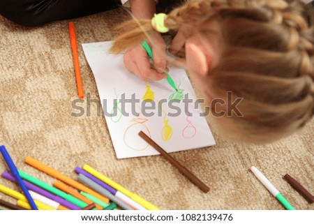 children draw with pencils sitting on the floor