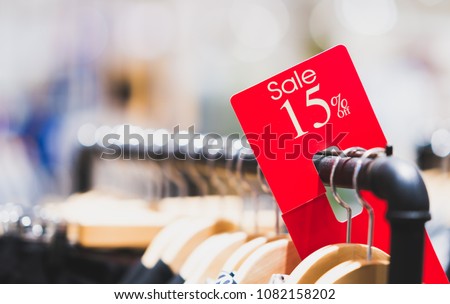 Red sale sign 15% discount on clothing rack in modern shopping mall or department store with copy space. Retail shop promotional event, new product discount, or business marketing advertising concept Royalty-Free Stock Photo #1082158202