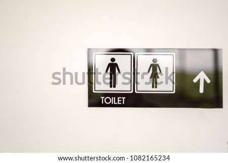 Signs to the toilet on the white walls