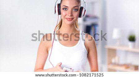 Woman with headphone listening music standing at home